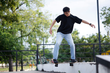 Obraz premium Young Asian Man Performing Skateboard Trick at Outdoor Skate Park