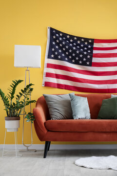 Interior of stylish living room with USA flag above brown sofa