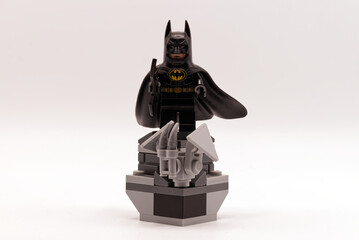 Obraz premium Bologna - Italy - April 2026: A batman lego minifigure standing on a grey brick pedestal against a white background.