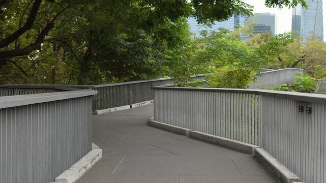 Elevated Walkway Through Lush Green Trees in Benchakitti Park Bangkok
