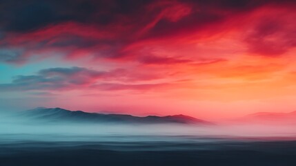 Fototapeta premium A vivid sunset paints the sky in fiery reds and oranges above a serene mountain silhouette, blending into deep blue mist and tranquil waters.