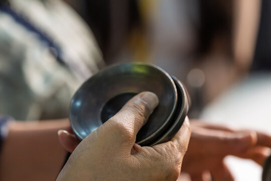 hands holding metal plates traditional musical instruments close up