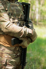 Obraz premium A soldier holds a machine gun in his hands close up
