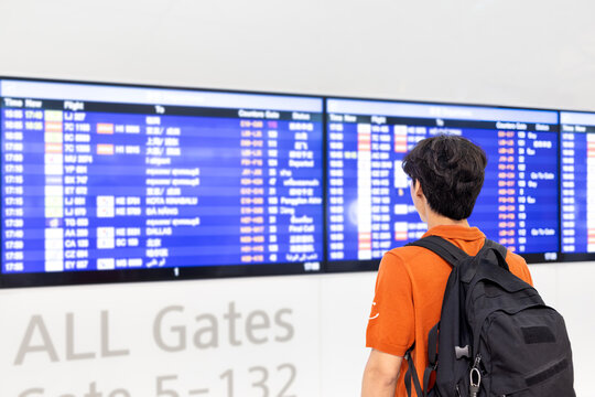 Young Korean Man with Backpack Checking Departure Board at Incheon International Airport