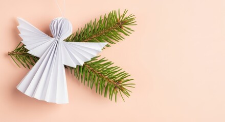 Obraz premium Paper angel ornament with fir tree branches on a soft pink background