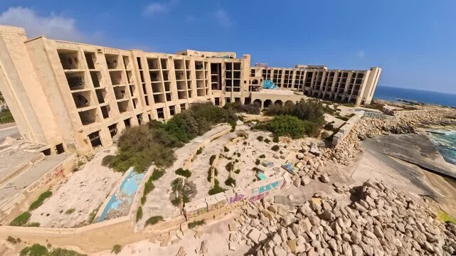 Aerial, wide, panoramic clip of salt pans, Saint Thomas tower and the abandoned resort hotel in Marsaskala, Malta