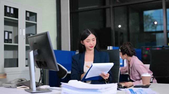  Business woman using tablet and laptop for doing math finance on an office desk, tax, report, accounting, statistics, and analytical research concept in office