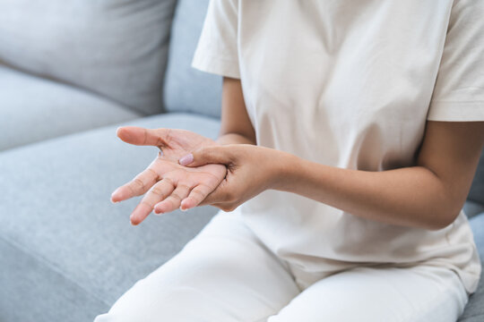Health care and medical concept, rheumatism asian woman hand pain from cramp, trigger finger, wrist pain touching massaging, hand holding ache joint, arthritis inflammation.Chronic disease from injury