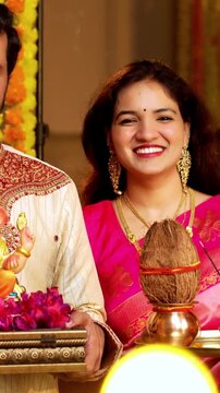 Indian Couple Welcoming Ganesh Idol with Joy, Young husband wife in Traditional Attire Holding Ganpati Bappa Idol, Puja Thali While Smiling and Chanting Bappa Morya During Ganesh Festival Celebration