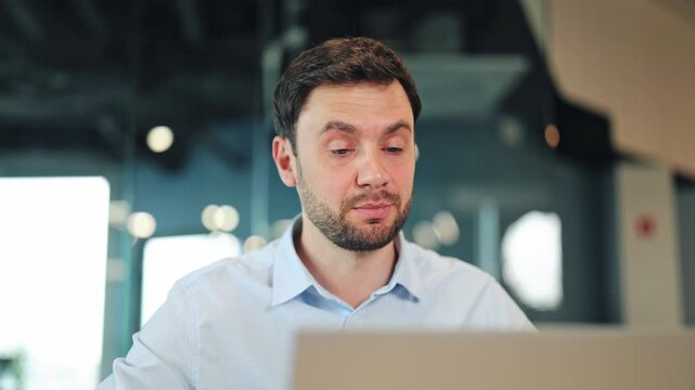 Close-up portrait of creative freelancer or designer speaking and gesturing at laptop screen during online conference. Remote worker having video chat or business meeting in modern coworking space.