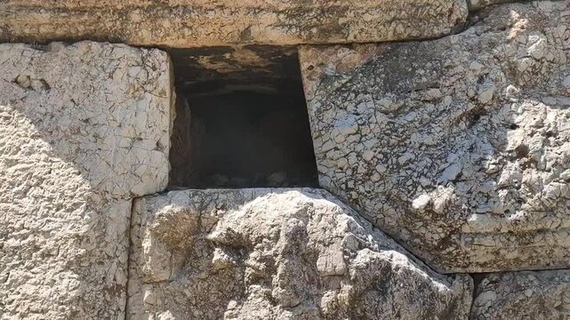 Prehistoric polygonal masonry wall at the Hill of the Nymphs, Athens, Greece, with megalithic stone blocks fitted without mortar.