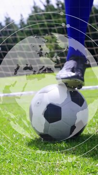 Vertical video: Sports player foot entering tapping soccer ball goal globe over ball prepping kick