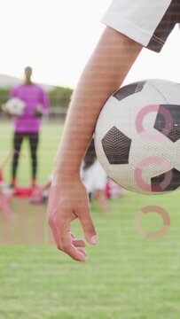 Vertical video: Male player holding ball, coach calling training, HUD overlay marking arm and ball