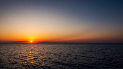 Obraz premium Tranquil Ocean Sunset with Radiant Golden Sky