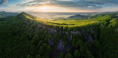 Naklejka premium Forest nature landcape with peak and sun at dramatic sunset