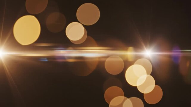 Golden light flare bokeh effect glowing warm bright circles abstract dark background with golden glow flare and soft focus radiant illumination sparkle shine orb festive atmosphere