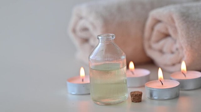 Elegant spa concept arrangement with aroma essential oil, burning candles and a diffuser symbolizing relaxation