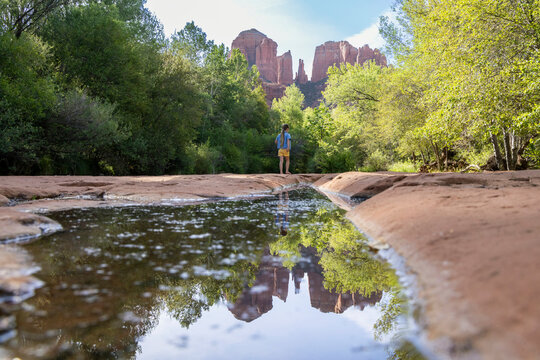 Lone girl in wilderness by reflecting pool