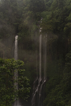 Misty multi-tier waterfall surrounded by lush jungle, Sekumpul, Bali