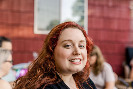 Smiling young woman with red hair outdoors