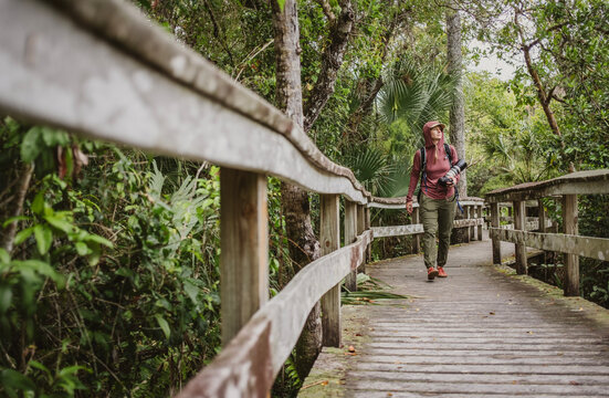 Woman with large camera looks for birds in Everglades National Park