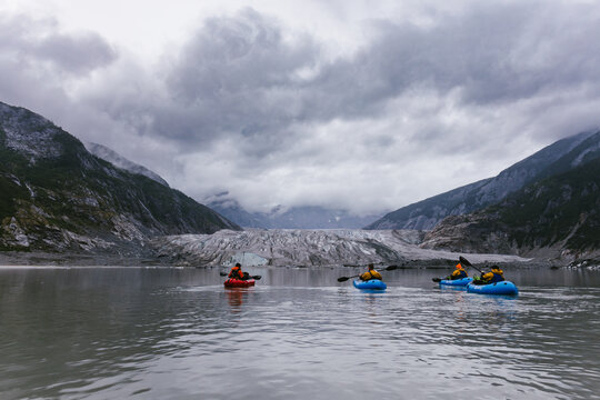 Group of people rowing towards a glacier on glacial lake