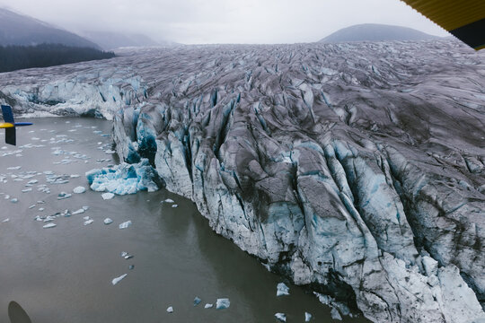 Glacier falling into a glacial lake photographed from above