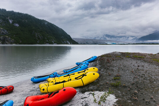 Blow up kayaks on the beach of a glacial lake with cloudy sky