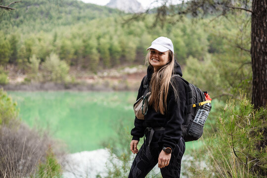Happy young woman on a hiking trail in forest