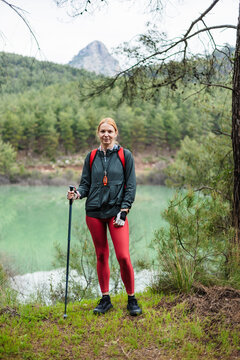 Woman hiker posing by a scenic mountain lake