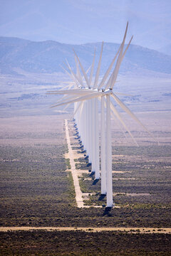 Wind turbines lined up across an arid landscape