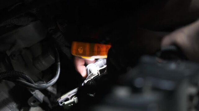 Close Up of Auto Mechanic Hands Repairing and Fixing Car Engine under the Hood in a Garage Workshop