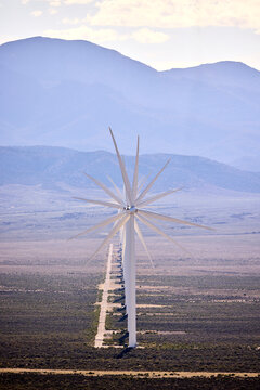 Row of wind turbines across a vast desert landscape