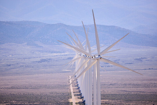 Long row of wind turbines in desert landscape
