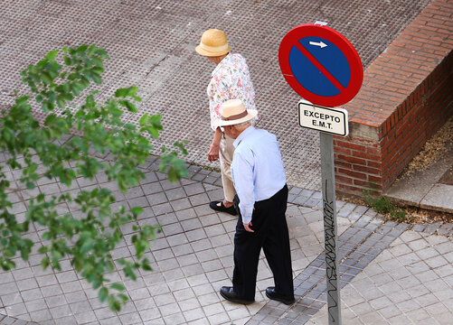 Esperanza de vida, longevidad y vejez matrimonio anciano con sombrero pareja de viejos elegantes paseando por acera calle