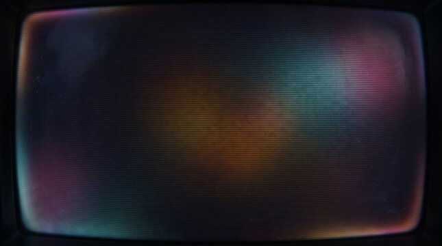 Abstract colorful light reflections on a dark, curved retro television screen, creating a mysterious and atmospheric visual.