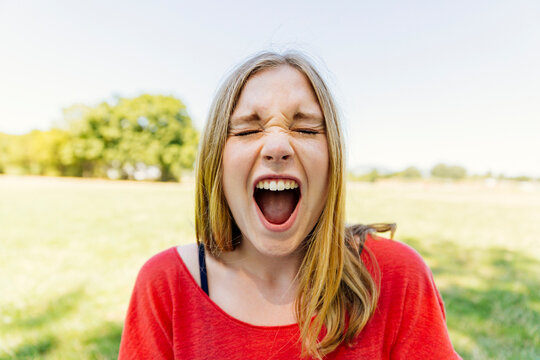 Portrait of teenage girl outdoors screaming