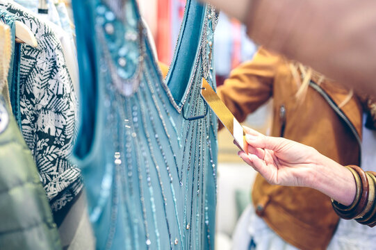 Close-up of woman checking price tag of a dress in a boutique