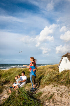 Family in a beach dune looking at view, Darss, Mecklenburg-Western Pomerania, Germany
