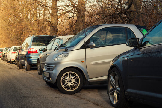 Small car parking sideways to the other cars