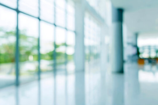 Bright abstract blurred background of a modern light blue interior space with large windows, offering clean copy space.