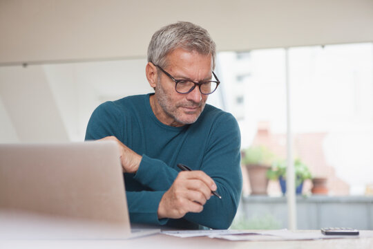 Mature man at home using laptop
