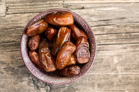 Bowl of dates on wood