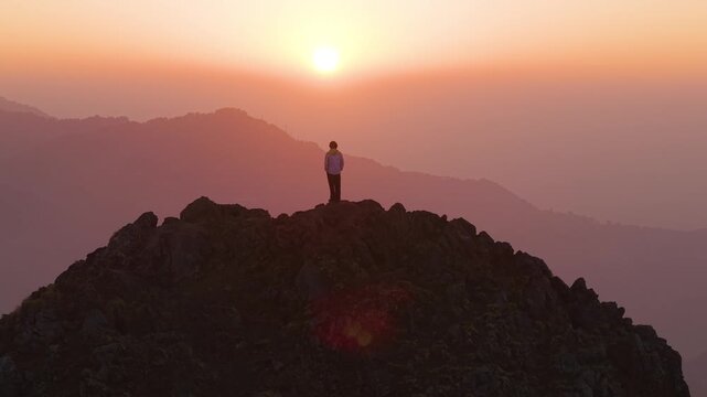 4K cinematic aerial footage of a boy enjoying breathtaking sunrise views over the Himalayas in Uttarakhand.