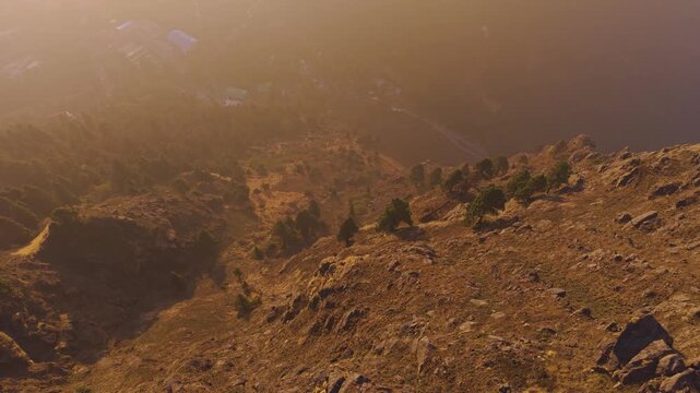 4K cinematic sunrise view with a boy standing on a cliff in the Himalayan mountains of Uttarakhand, India.