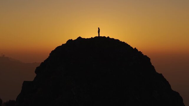 4K cinematic mountain sunrise footage with a lone traveler standing above the Himalayan valleys in Uttarakhand.