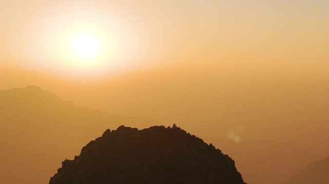 4K cinematic footage of a lone boy enjoying the sunrise over Himalayan mountains in Uttarakhand, India.