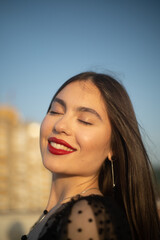 Fototapeta premium Portrait of a young and sensual woman smiling on a building rooftop