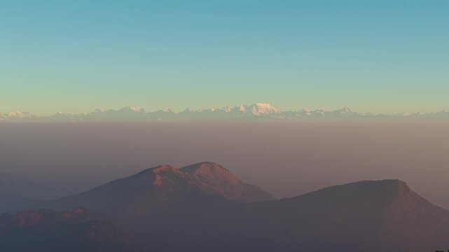 4K drone shot of sunlit snow-covered Himalayan peaks and dramatic mountain landscapes in Uttarakhand, India.