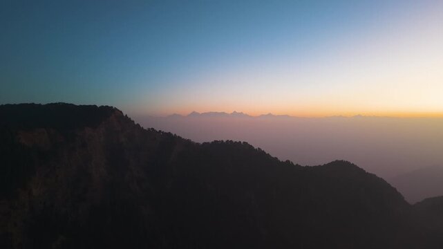 4K aerial footage of the Himalayan mountain range featuring Trishul and Nanda Devi peaks during golden sunrise light.